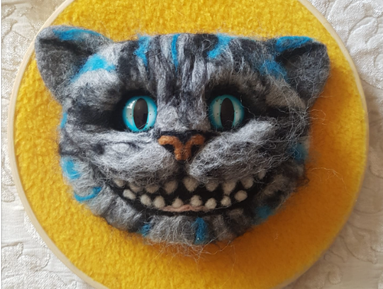 żółty filcowy kwiat na tle drewna i jesiennych liści